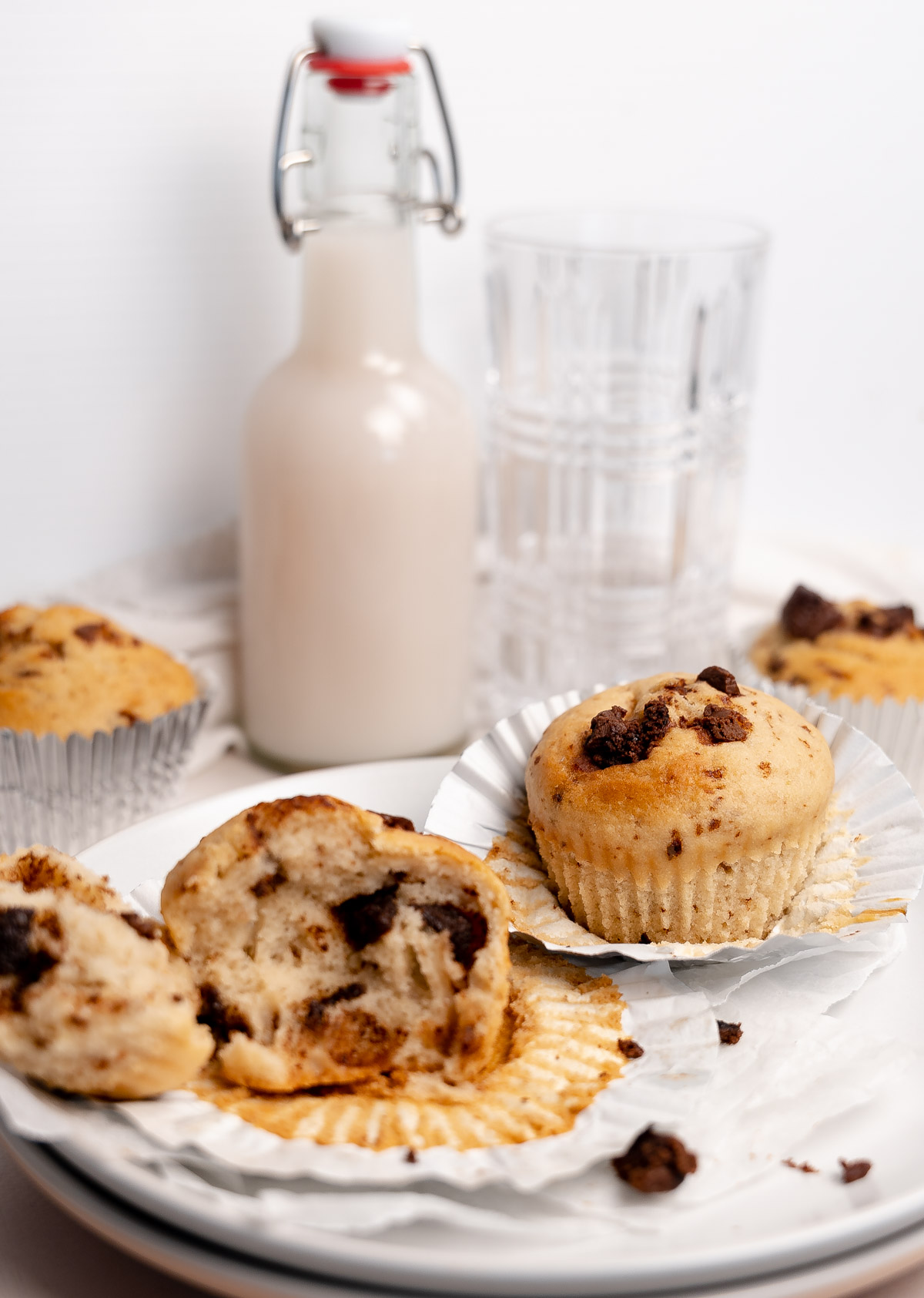 two chocolate chip muffins on a plate with one opened