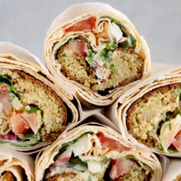 a stack of pita sandwich rolls filled with falafel and veggies
