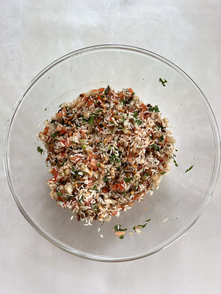 rice, vegetables, herbs and pine nuts filling in a glass bowl