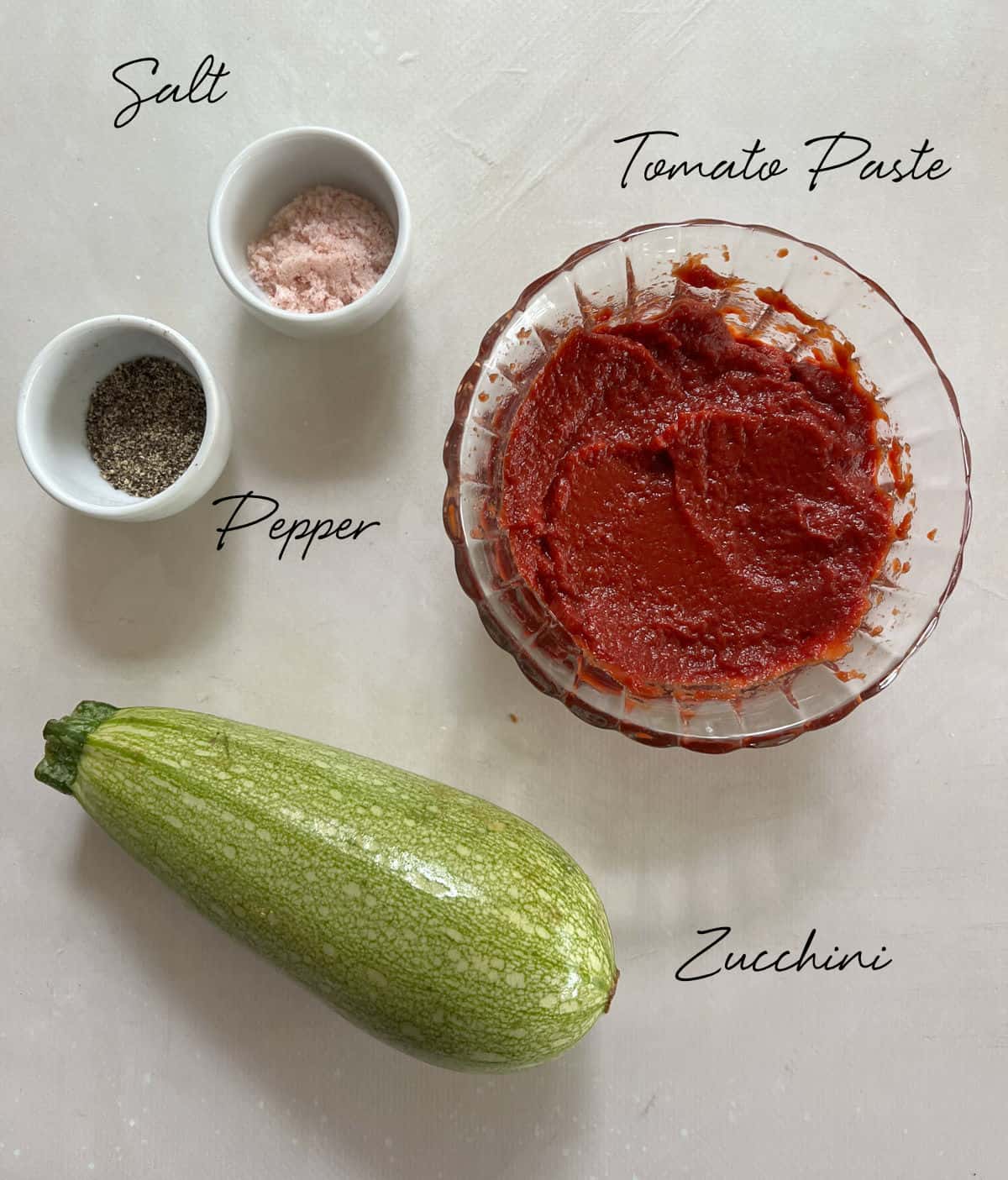 zucchini, tomato paste, salt and pepper laid out