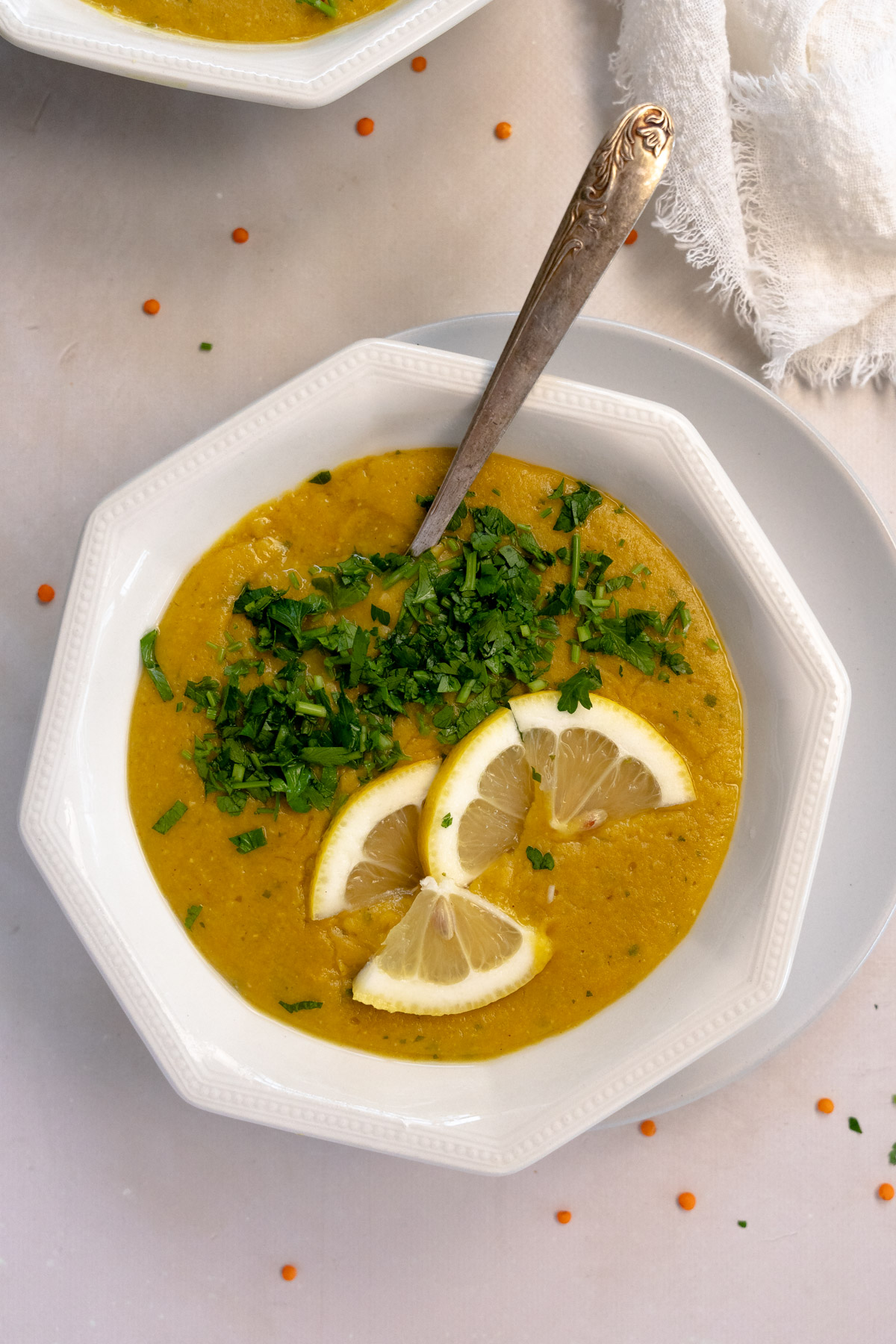 lebanese lentil soup in a white bowl with a spoon