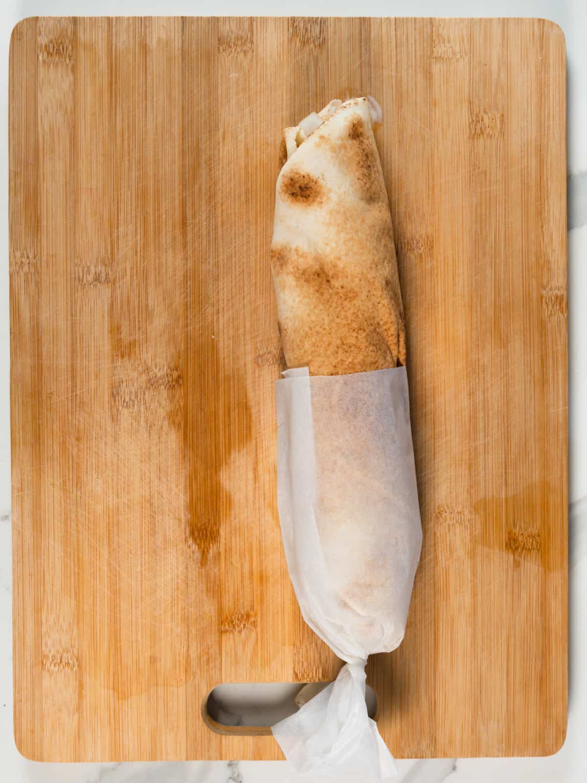 a pita roll with paper wrapped around half of it