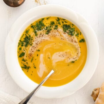 a bowl of orange colored butternut squash soup with coconut milk