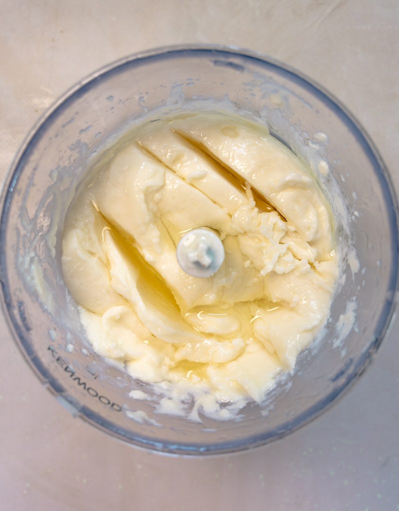 garlic sauce in a food processor with oil on top