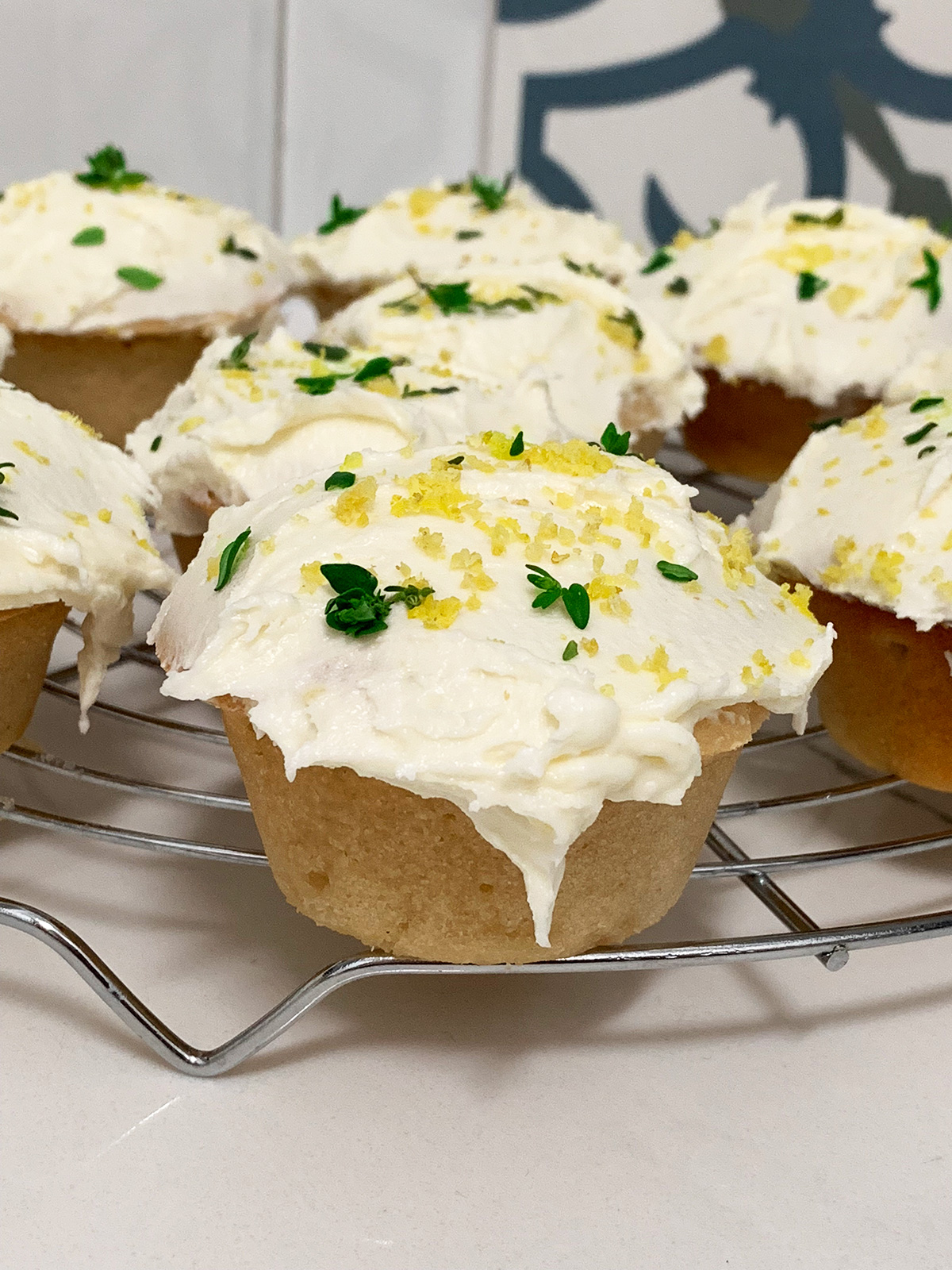 Lemon and thyme cupcakes sitting on a wire rack