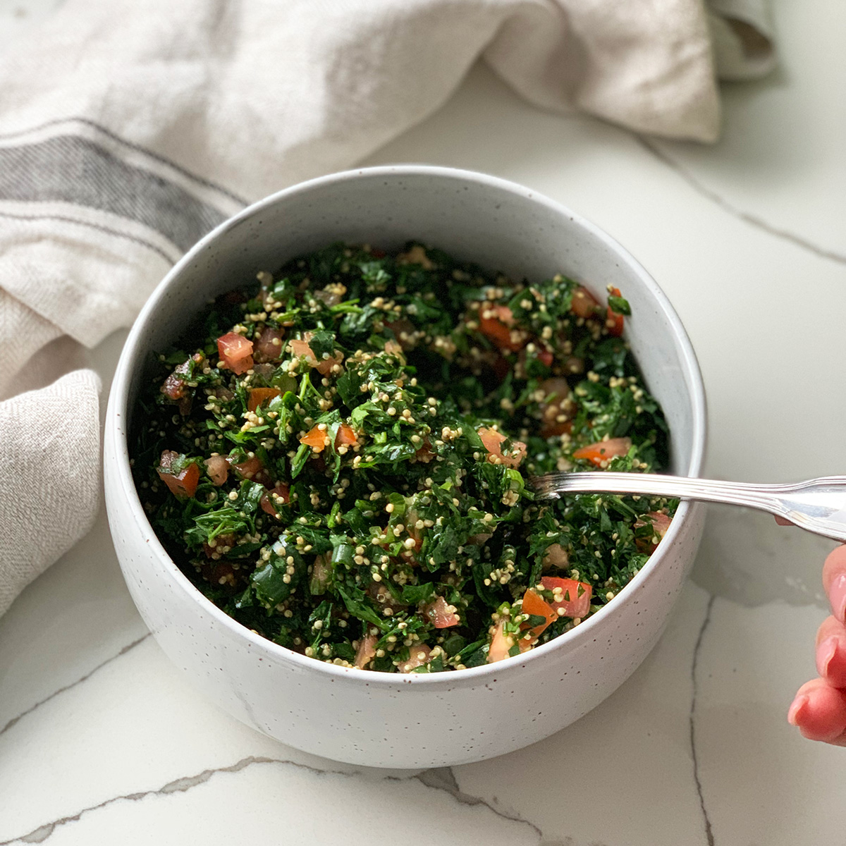 Quinoa Tabouli (tabboule in served in a white bowl)