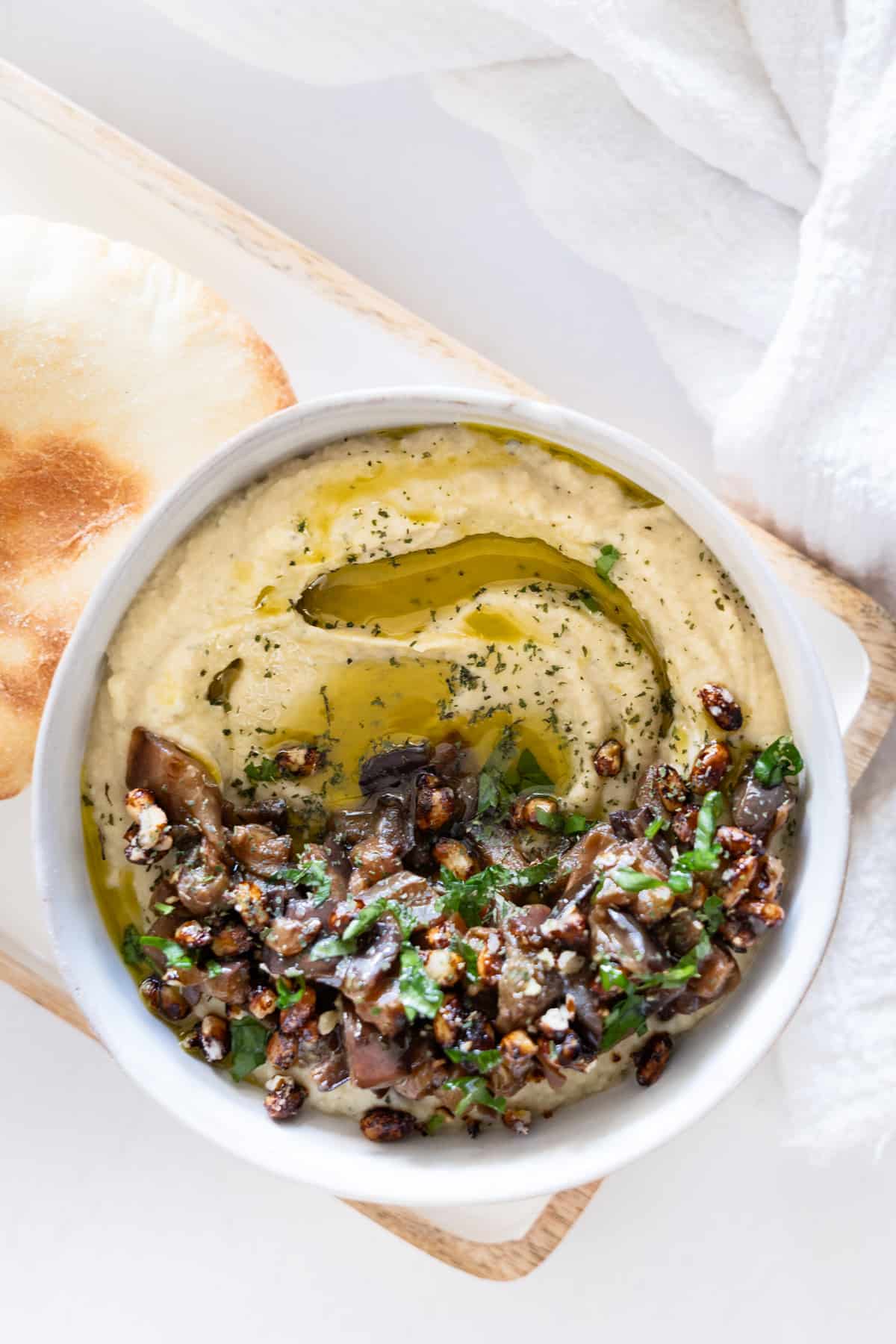 a bowl filled with a creamy eggplant dip topped with chopped cooked eggplant