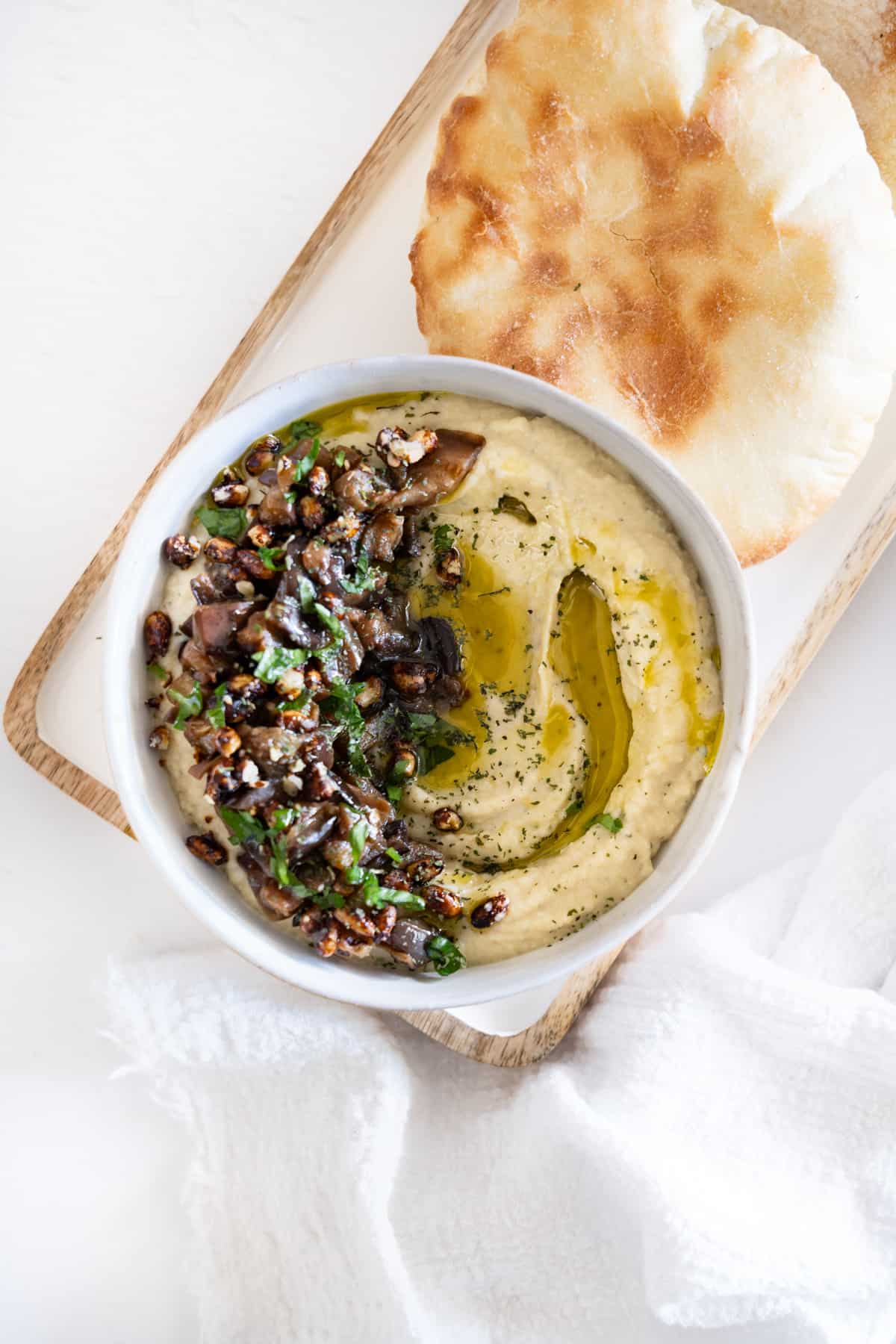 a bowl of baba ganoush with pita bread on the side