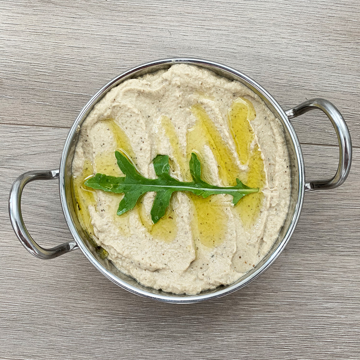 Lebanese Baba Ghanouj dip with Mint served in a steel bowl and garnished with olive oil and rocket