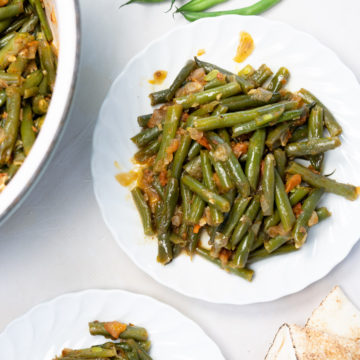 a white plate with braised green beans