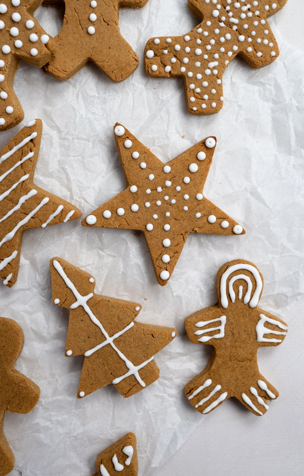 gluten-free gingerbread cookies with white vegan royal icing on them