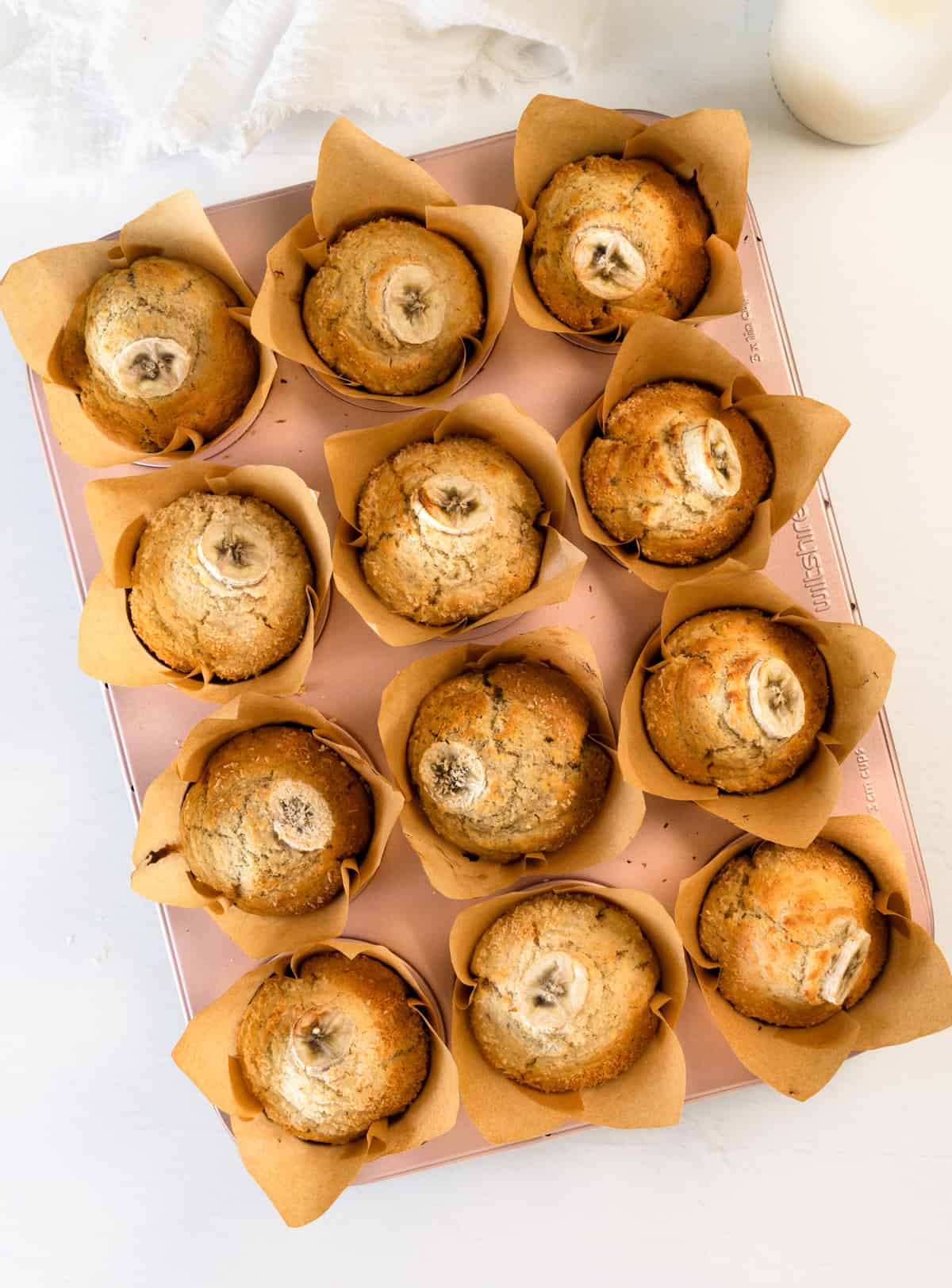 a pink muffin tray filled with muffins