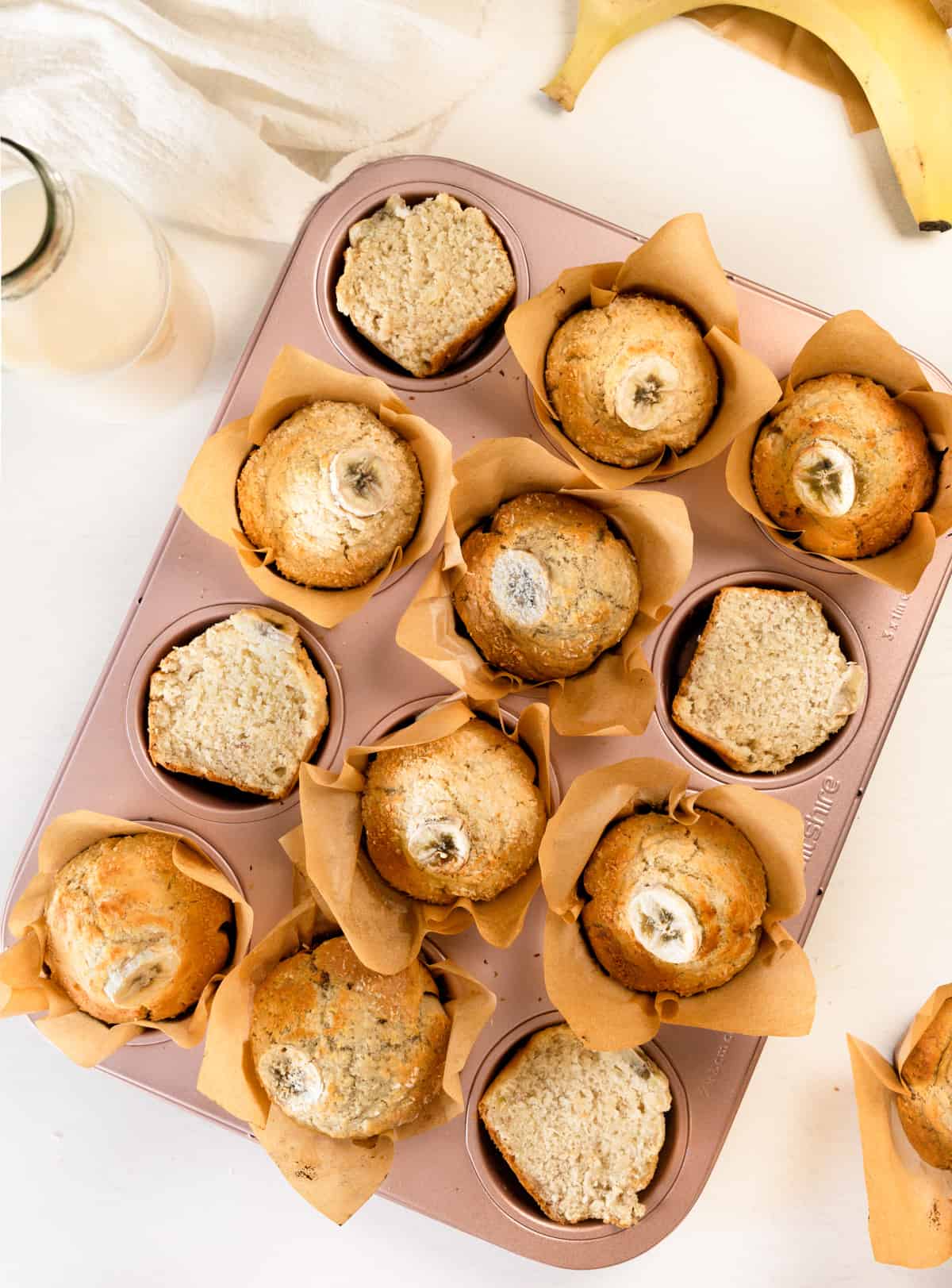 a muffin tray filled with muffins, some cut in half showing the insides