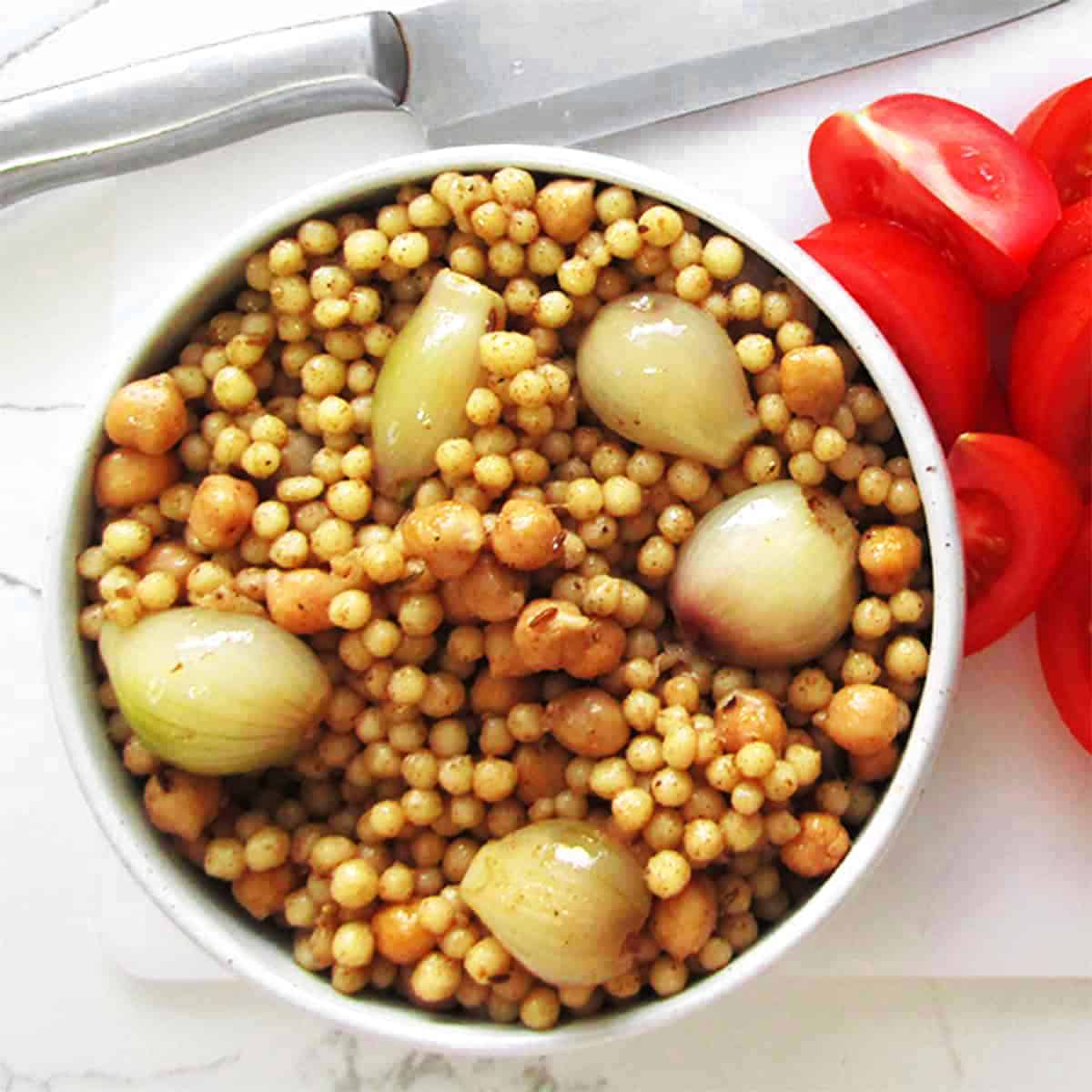 pearl couscous with pearl onions and chickpeas in a bowl