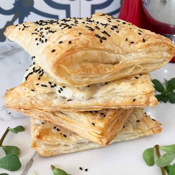 a stack of puff pastry pockets with purslane around them