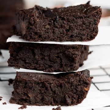3 brownies stack up on each other with paper in between each layer