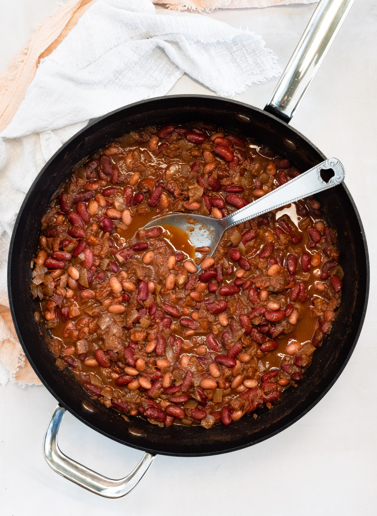 a black pot of red kidney beans in tomato sauce