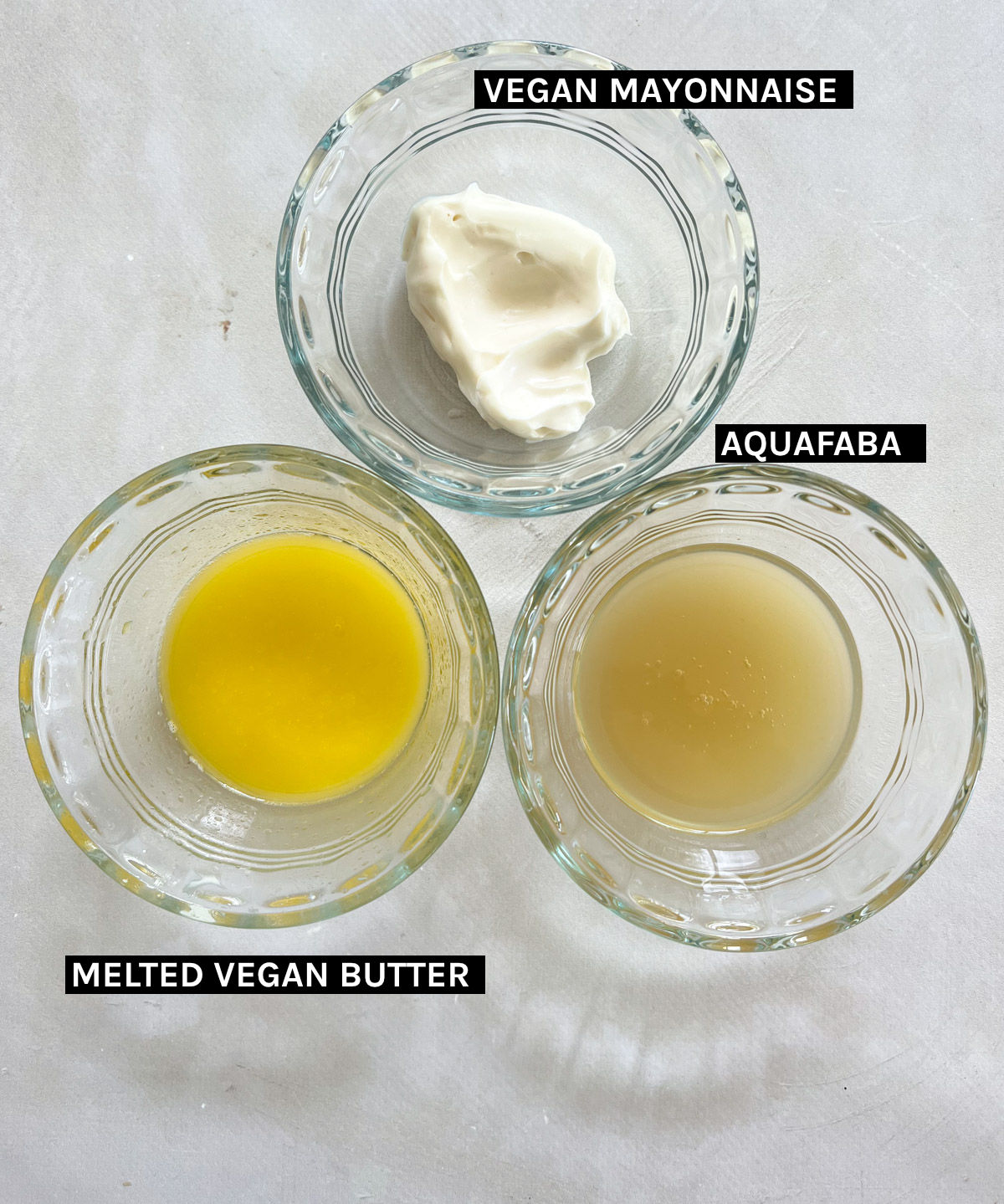 vegan mayonnaise, melted vegan butter and aquafaba in three glass bowls