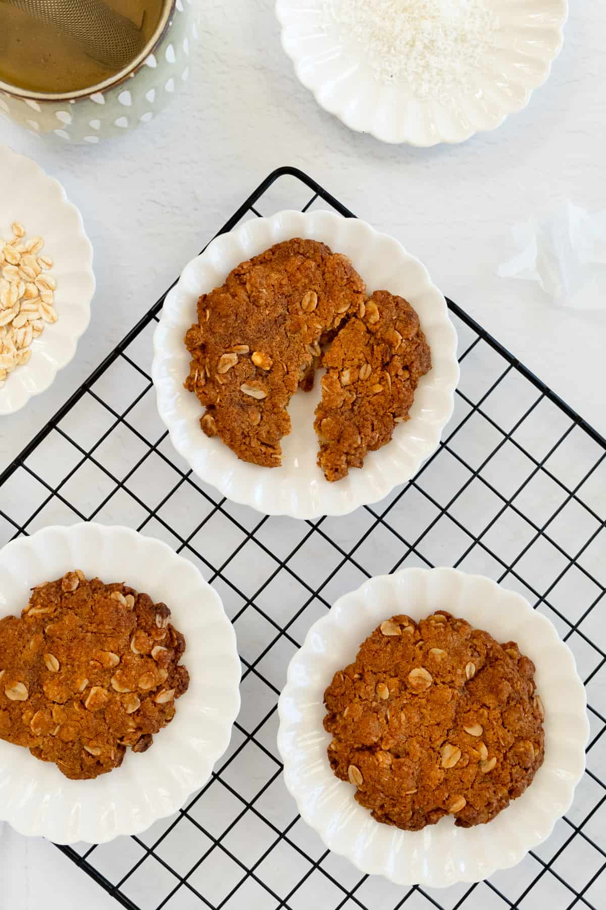 three white plates with a reddish brown biscuit in each