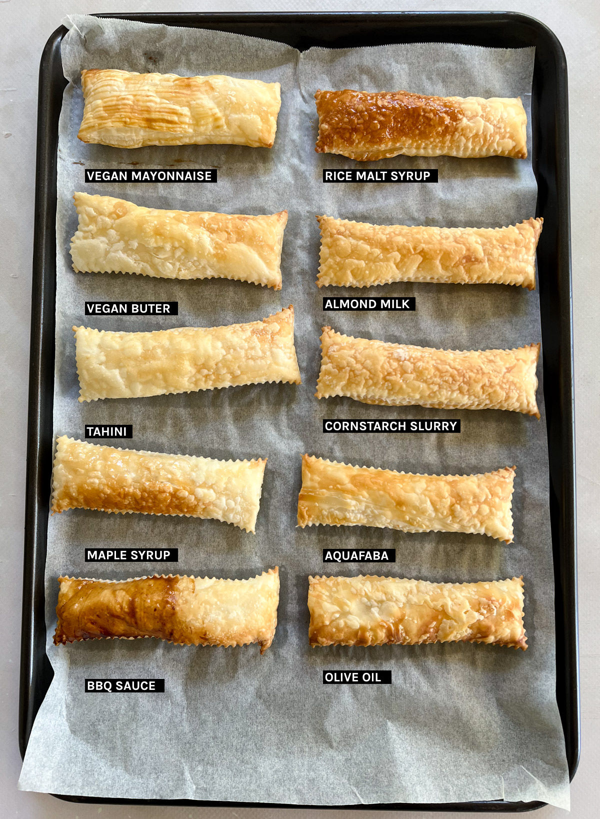 a tray of puff pastry strips with different egg wash substitutes