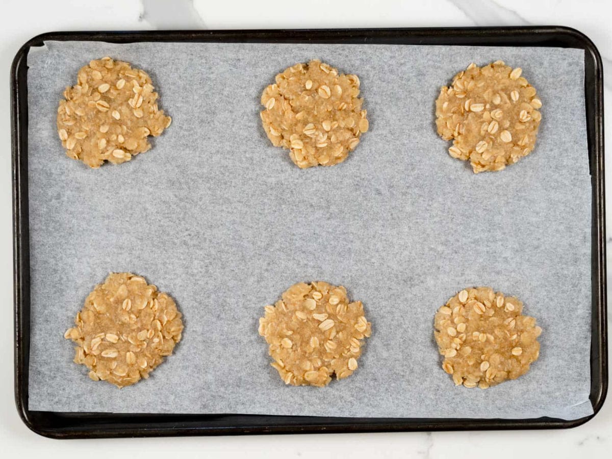 unbaked ANZAC biscuits in a baking tray