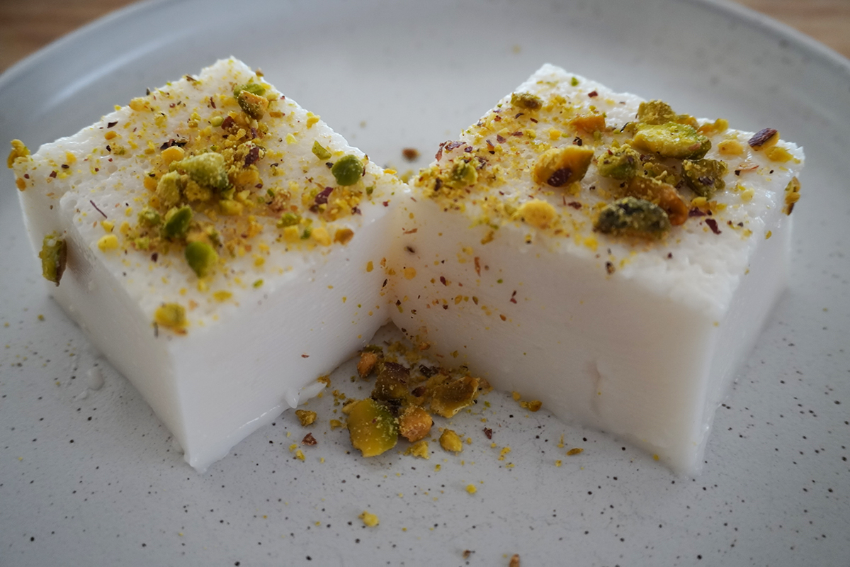 Two slices of haytaliyeh with crushed pistachios on top