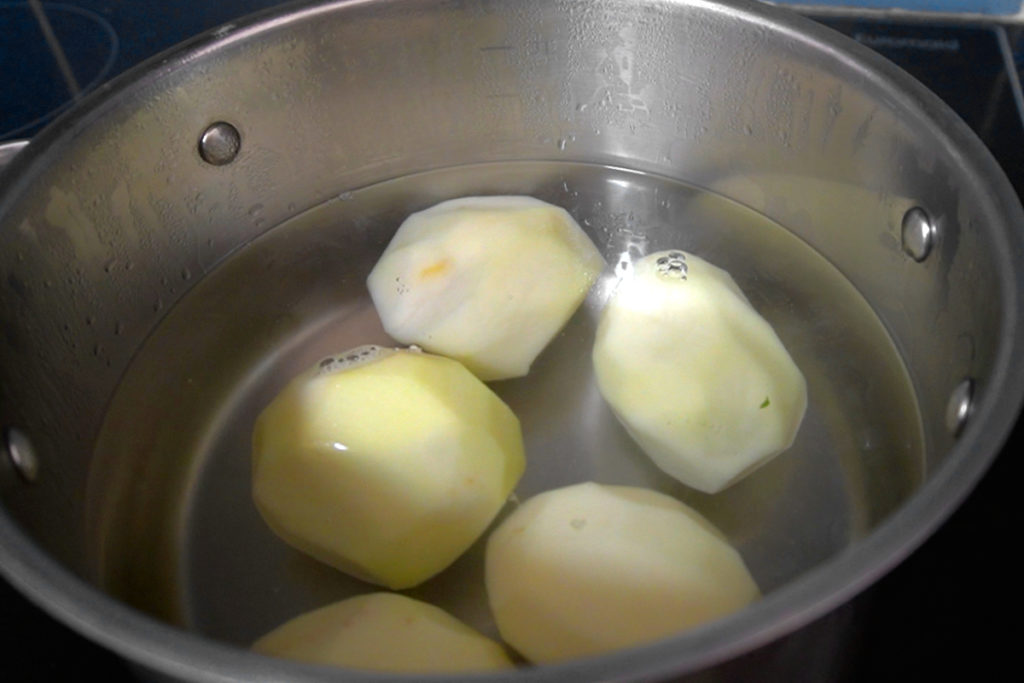 boiling peeled potato in a pot
