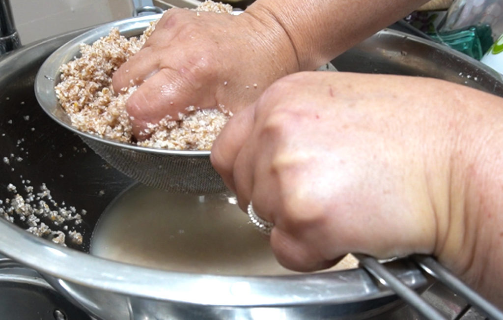 straining bulgur by hand in a sieve