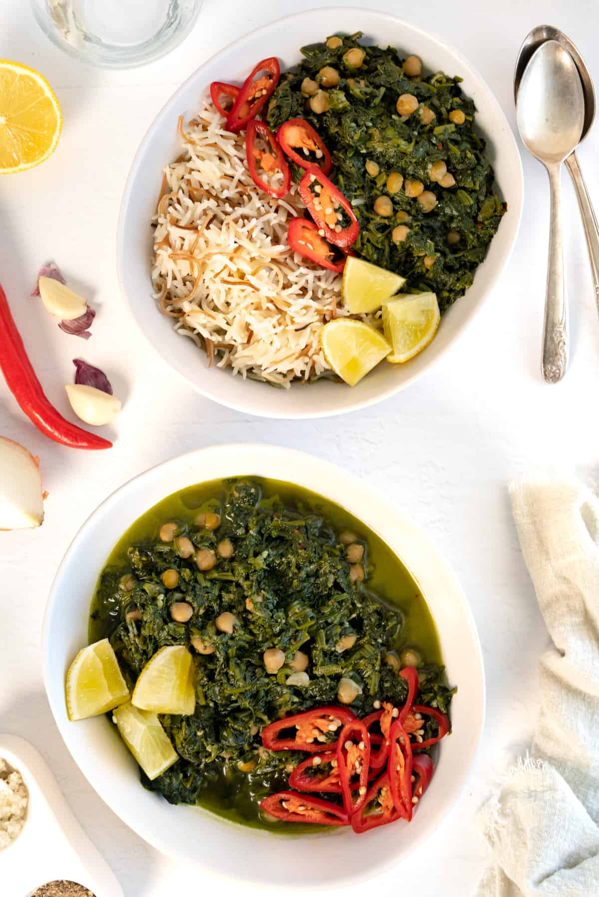 two white bowls with stewed spinach and one with cooked white rice also