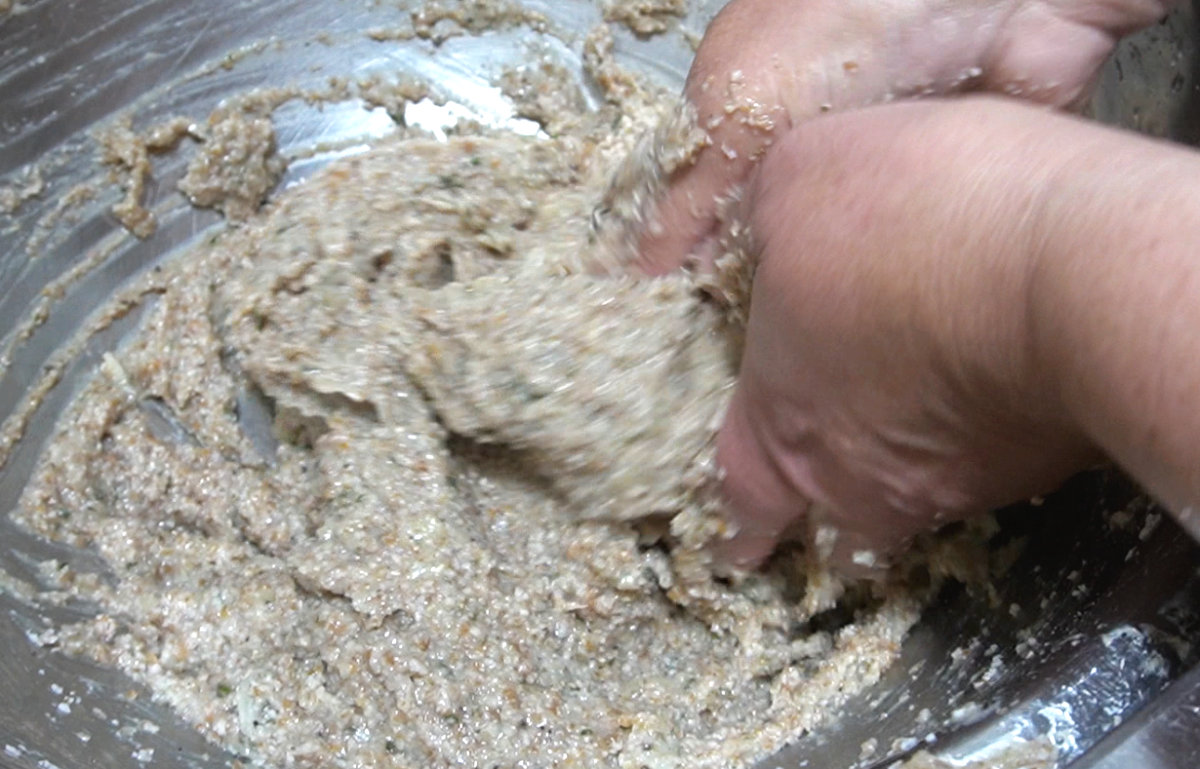 working kibbeh dough by hand in a bowl