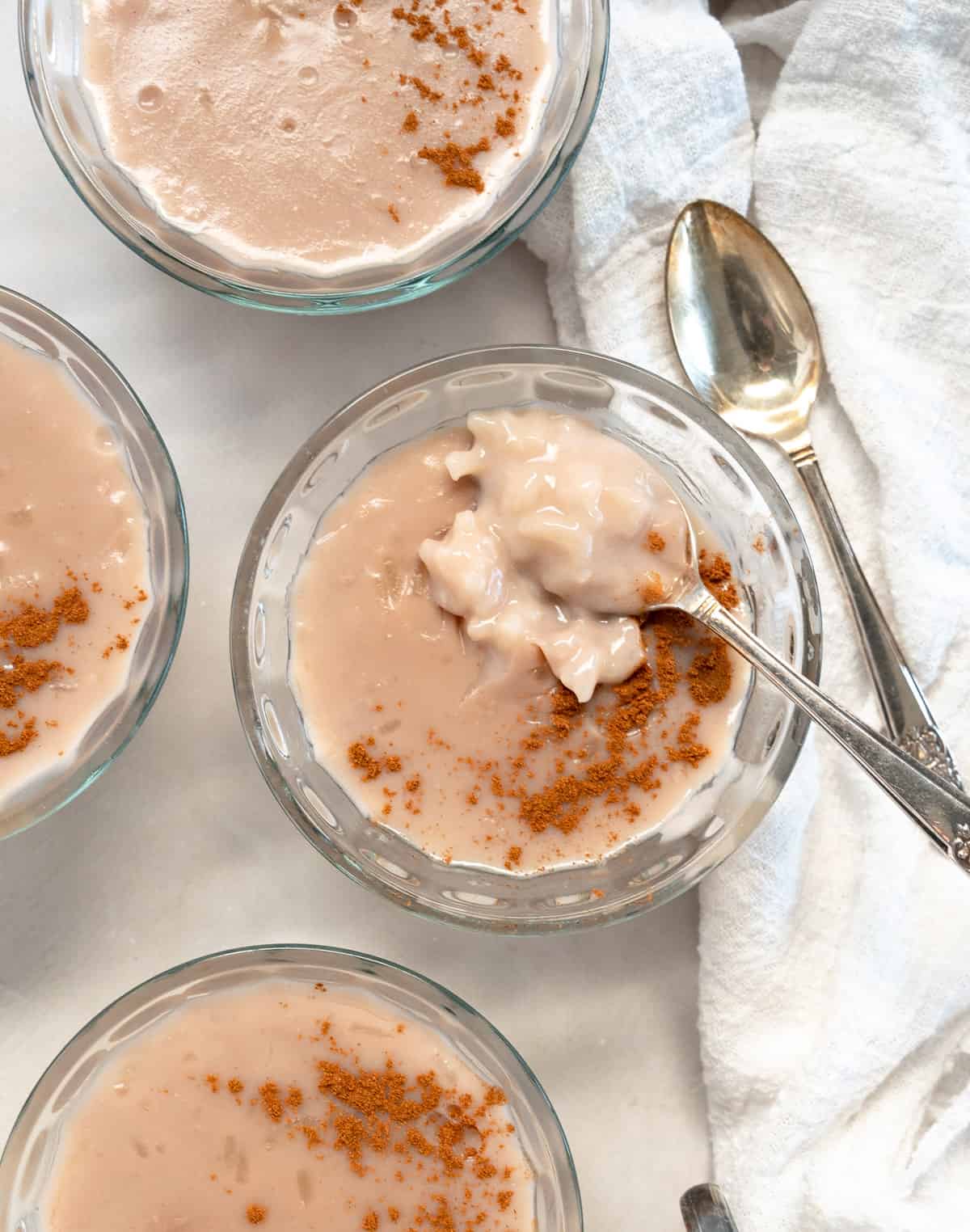 pinkish rice pudding in a bowl with a teaspoon in it