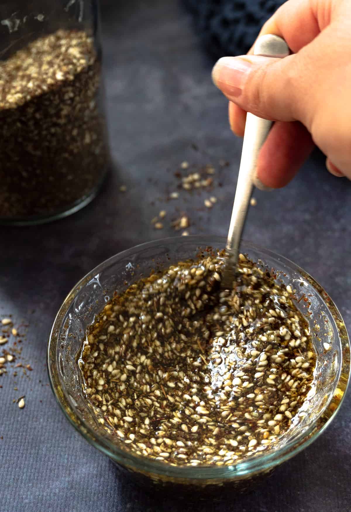 mixing zaatar with olive oil in a glass bowl