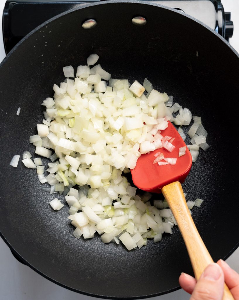 sweating onion in a black pan