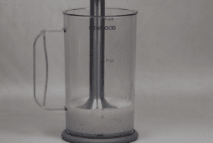 Immersion blender in tall bowl with ingredients