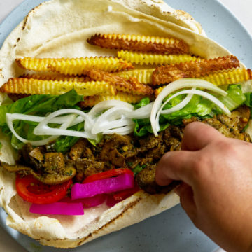 Vegan shawarma roll with a hand