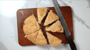 cutting up freshly baked damper bread
