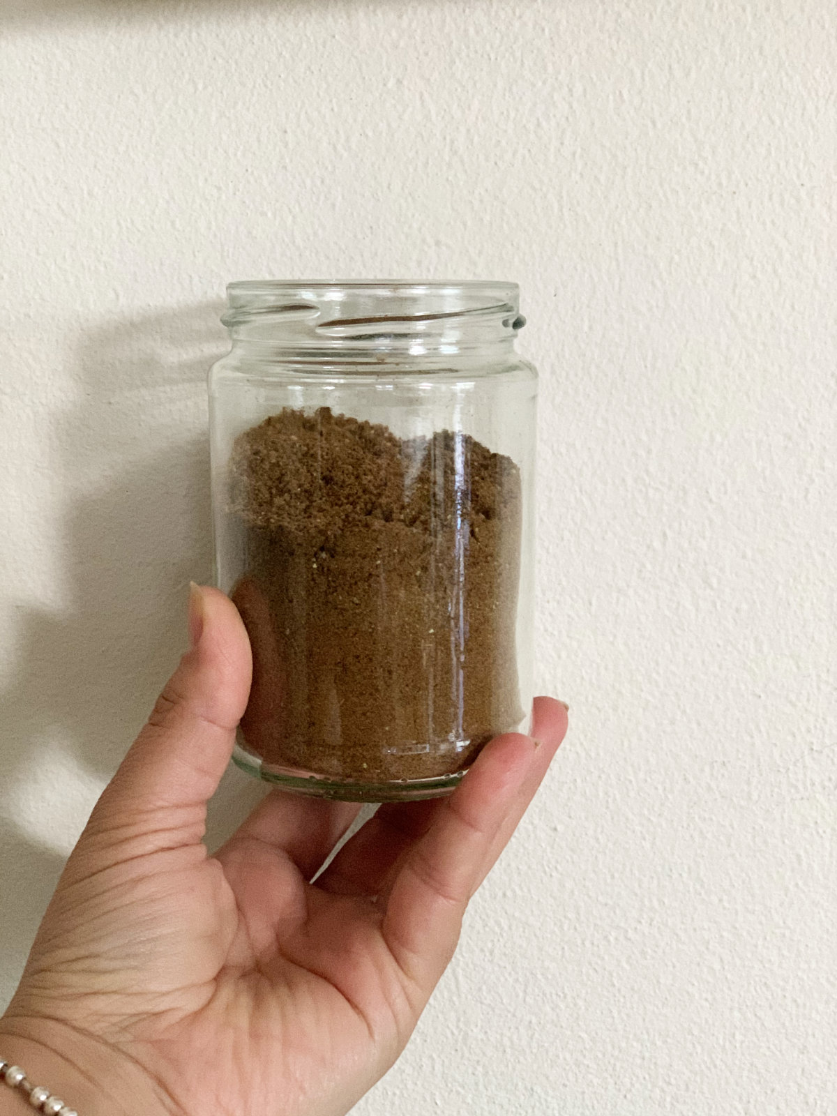 baharat in a recycled jar held by a female hand