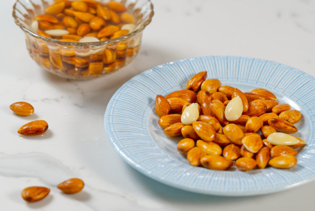 Almonds soaked in water and on a blue plate