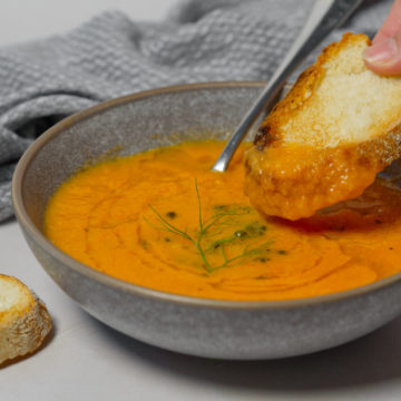 dunking bread into tomato soup