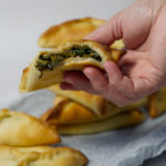 lebanese spinach pie held in a hand
