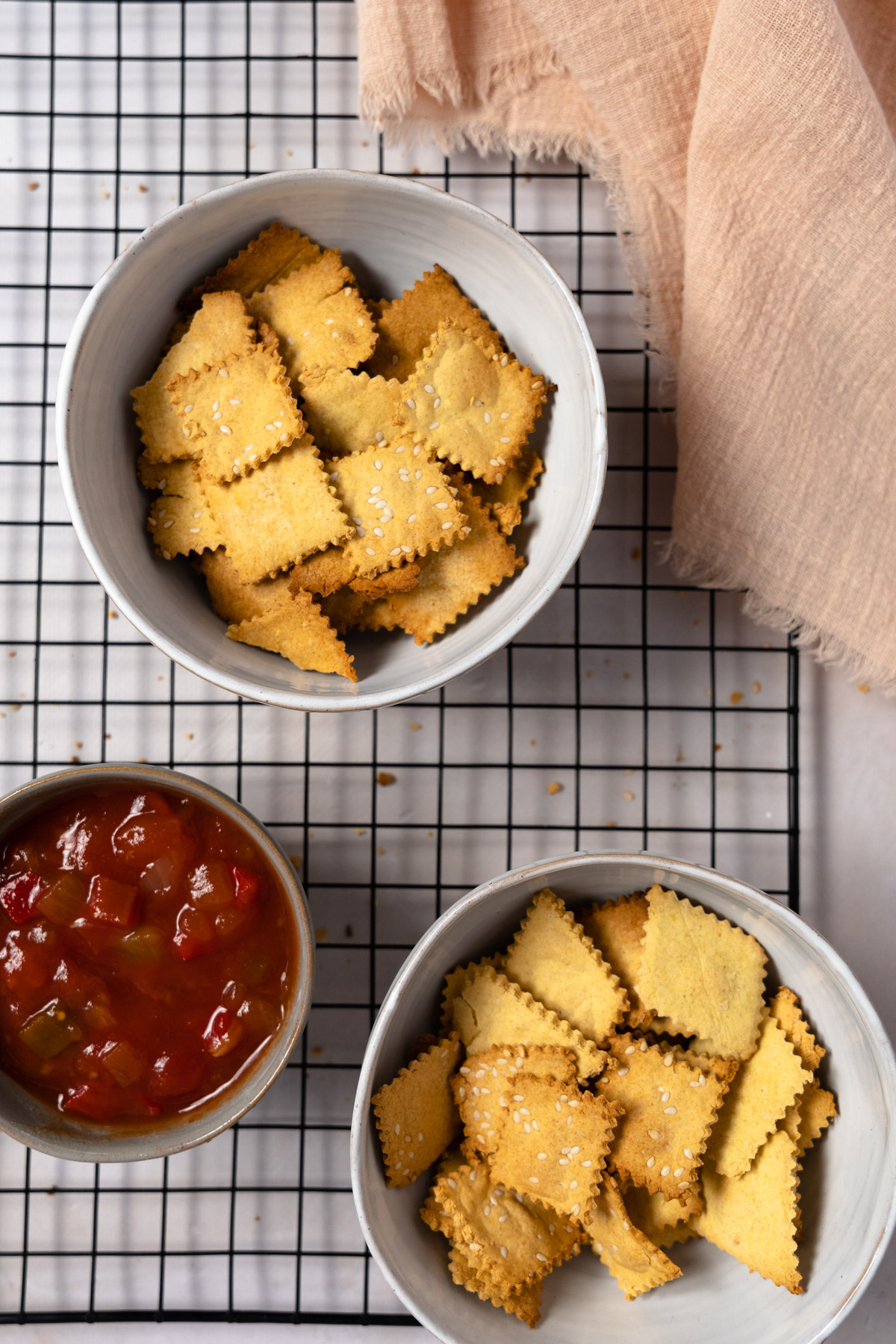 two bowls of gluten free crackers with salsa on the side
