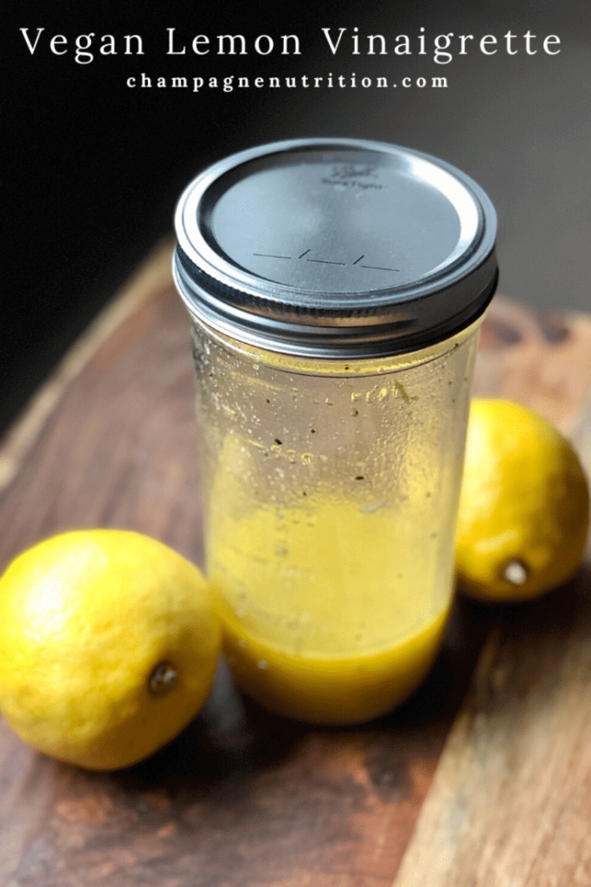 vegan lemon vinaigrette in a baller jar with two lemons on the side
