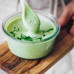 green ranch sauce in a bowl with a spoon dipped into it