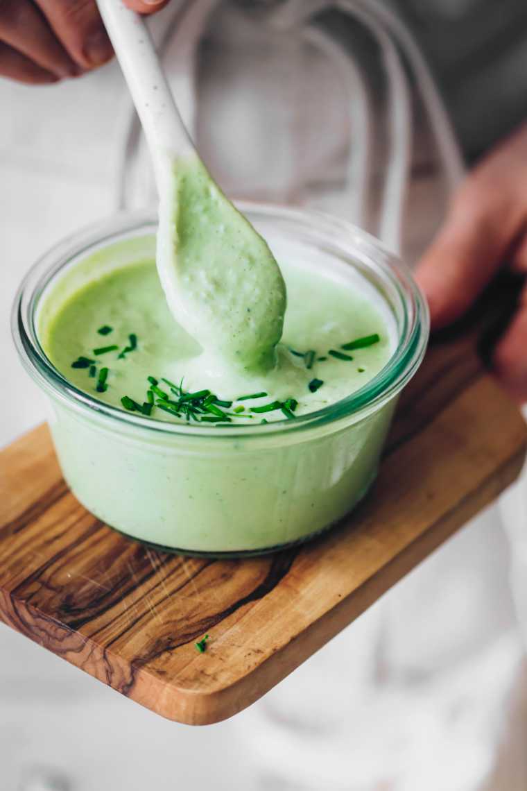 green ranch sauce in a bowl with a spoon dipped into it