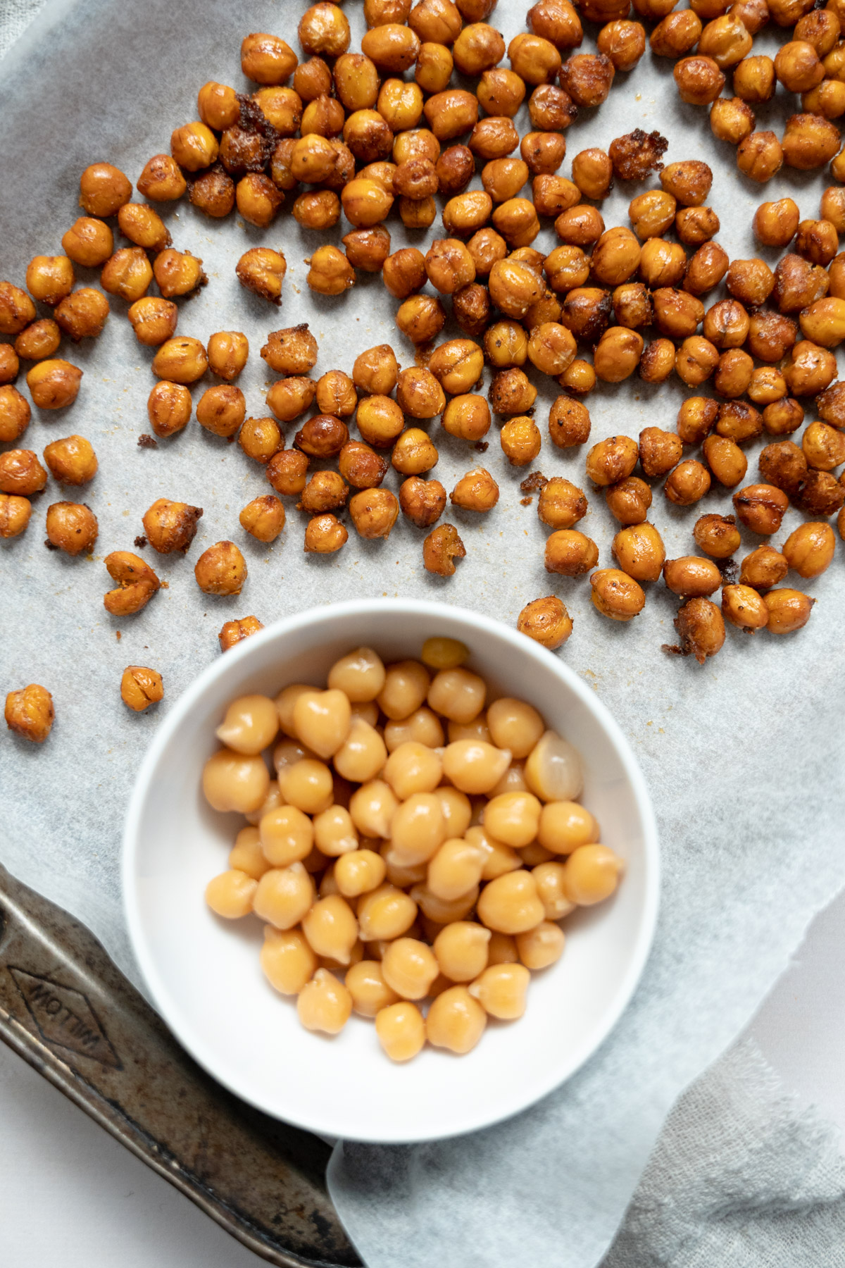 cooked chickpeas in a bowl with roasted chickpeas in a tray