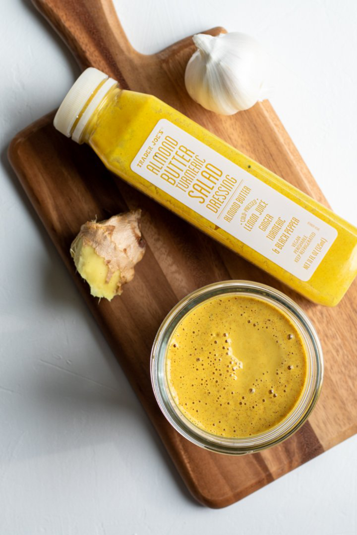 ginger turmeric dressing in a bowl with a trader joe bottle next to it