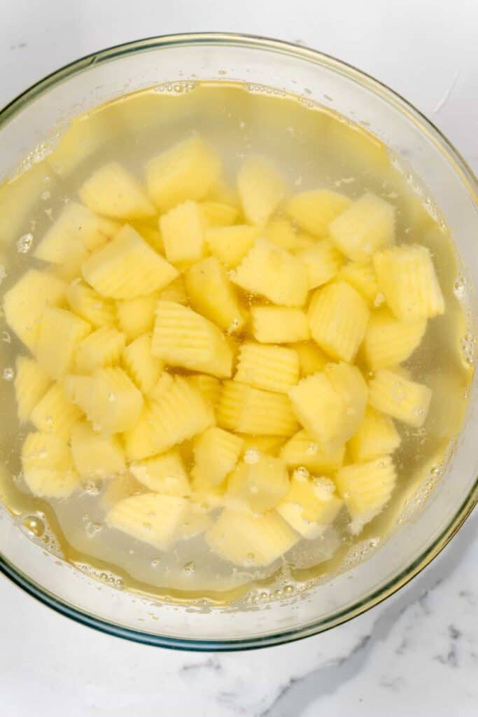 cubed potatoes in a bowl of water