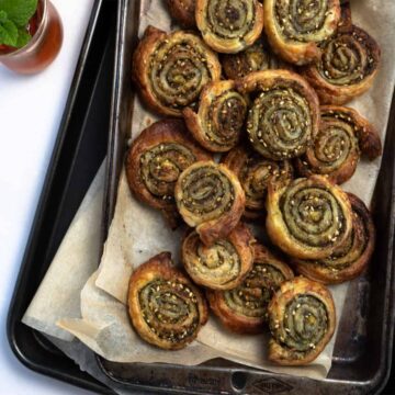 a stack of trays with zaatar pinwheels