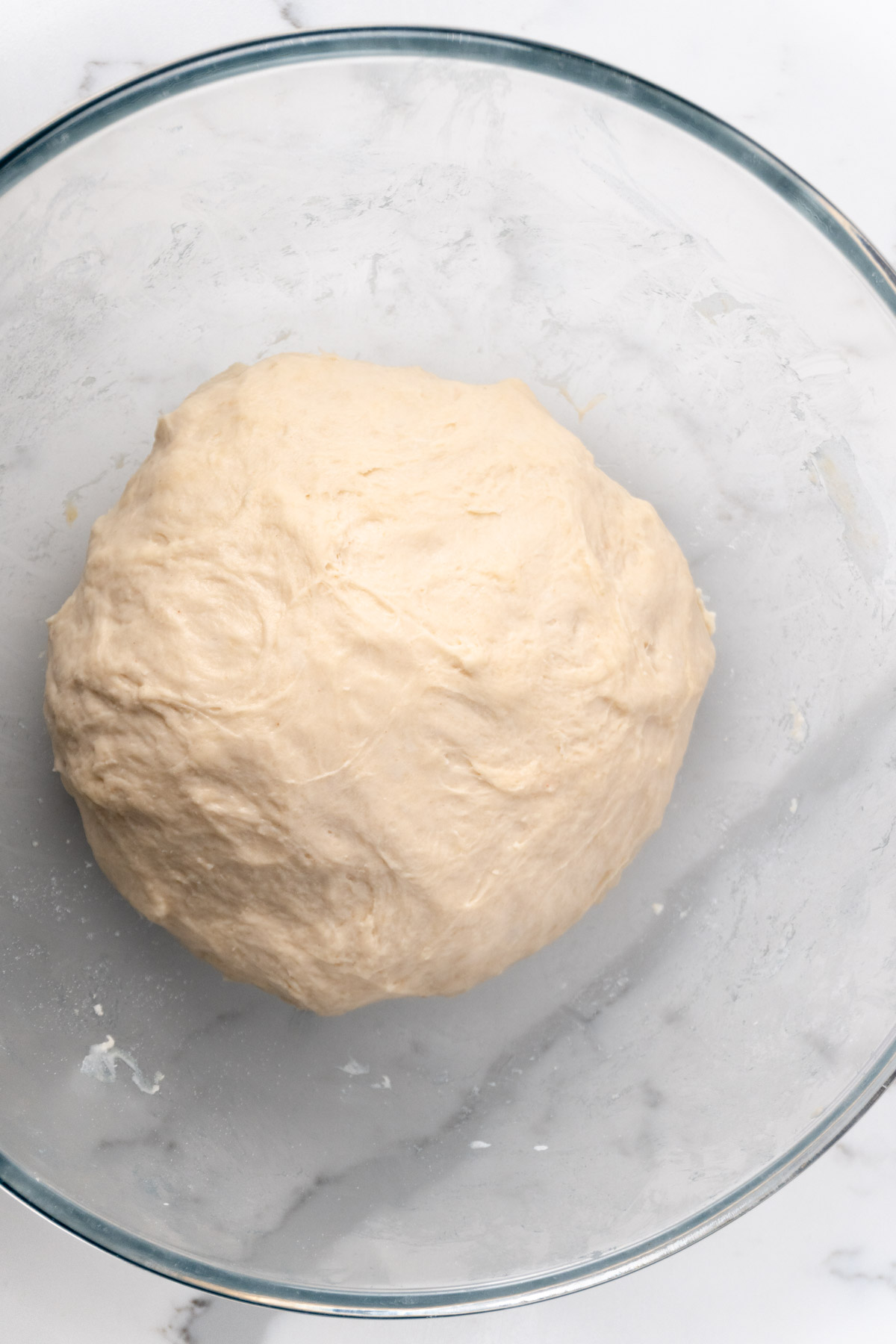 basic pizza dough in a glass bowl