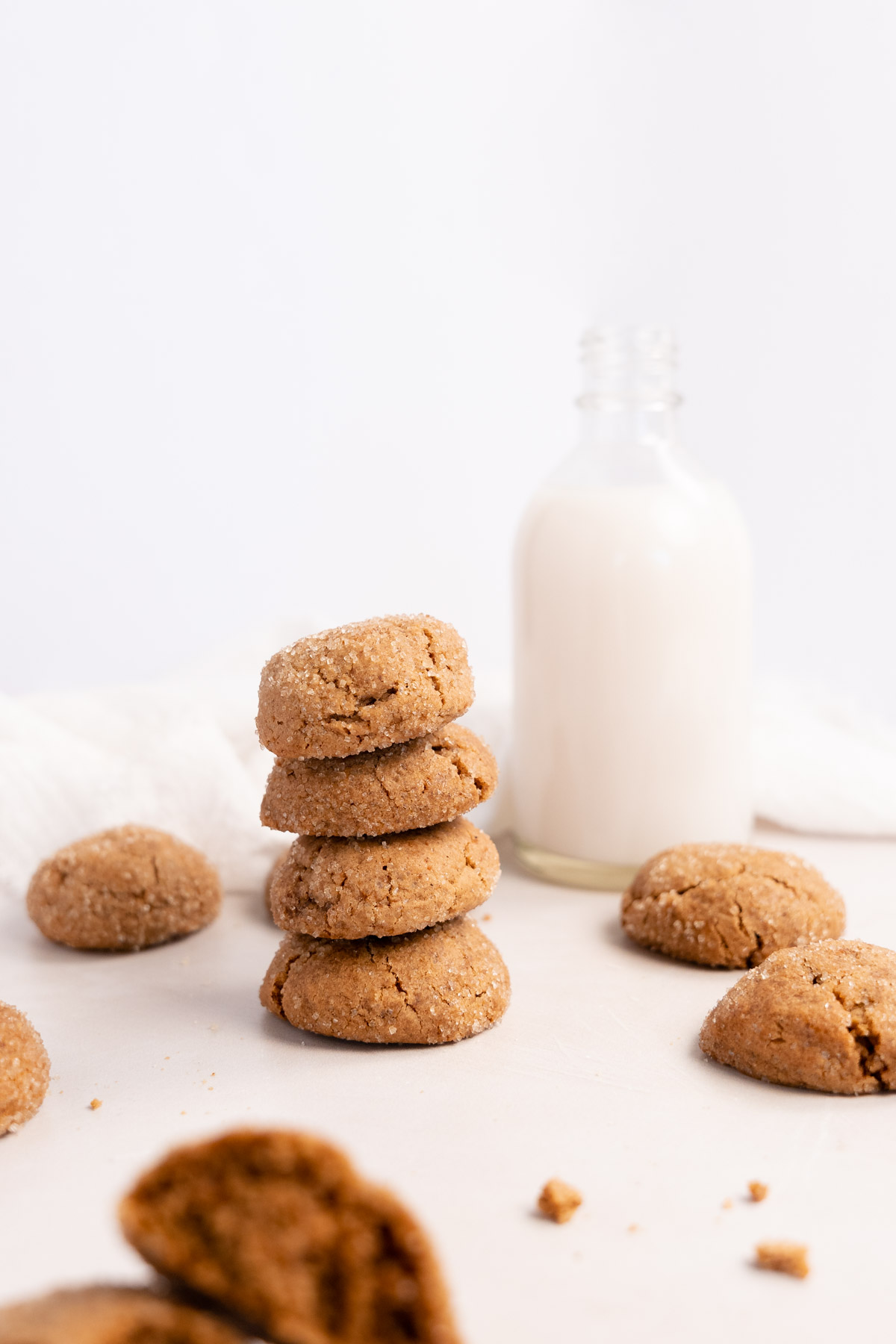 four ginger biscuits stacked on top of each other with a bottle milk on the side
